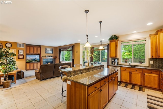 17544 SW Keystone Ct, Beaverton, OR 97007 - kitchen featuring light tile patterned floors, dishwasher, a kitchen breakfast bar, a sink, and open floor plan