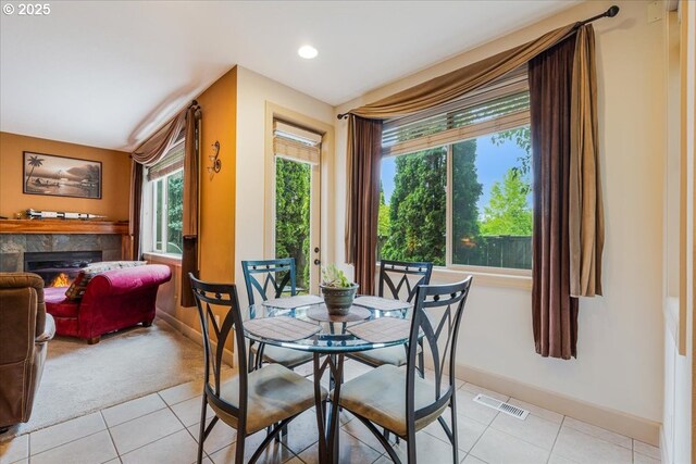 17544 SW Keystone Ct, Beaverton, OR 97007 - dining space featuring light tile patterned floors, baseboards, light colored carpet, a warm lit fireplace, and recessed lighting
