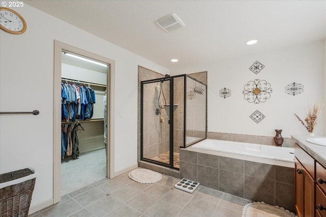 17544 SW Keystone Ct, Beaverton, OR 97007 - full bathroom with a bath, a shower stall, tile patterned flooring, a spacious closet, and vanity