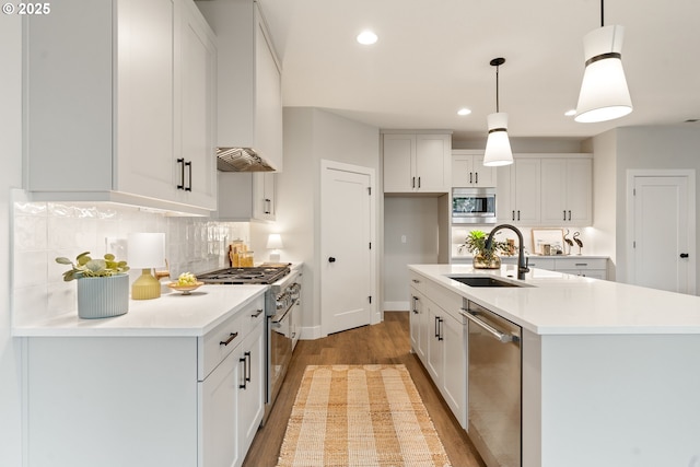 2901 NW 114th Ter, Portland, OR 97229 - kitchen featuring stainless steel appliances, a sink, light wood-style flooring, decorative backsplash, and light countertops