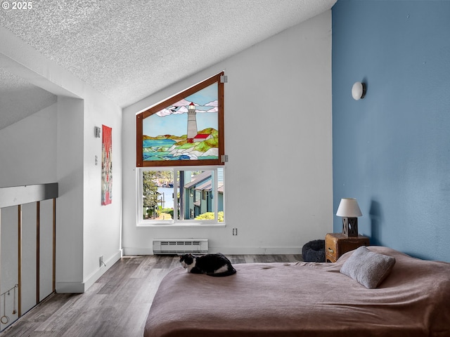 346 NE Skipanon Dr Unit 46, Warrenton, OR 97146 - bedroom featuring baseboard heating, a textured ceiling, and wood finished floors