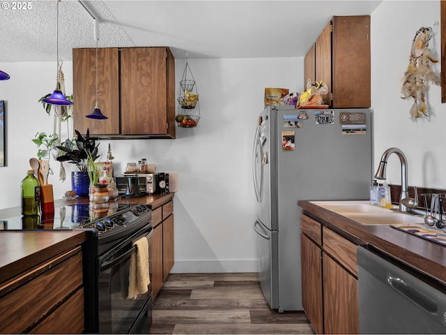 346 NE Skipanon Dr Unit 46, Warrenton, OR 97146 - kitchen featuring black electric range, dishwashing machine, dark countertops, freestanding refrigerator, and dark wood-style flooring