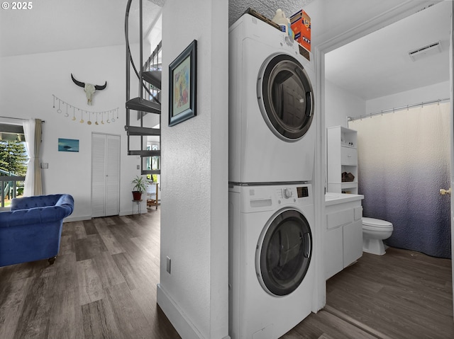 346 NE Skipanon Dr Unit 46, Warrenton, OR 97146 - laundry room with stacked washer / dryer, wood finished floors, plenty of natural light, and a textured wall