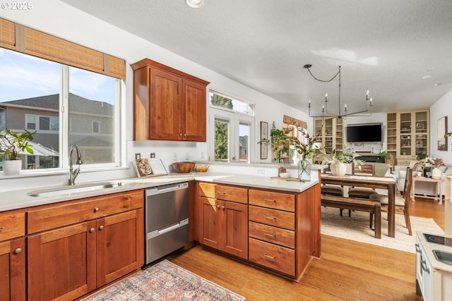 13765 SW Florentine Ave, Portland, OR 97223 - kitchen with a sink, stainless steel dishwasher, a peninsula, light wood-style floors, and light countertops