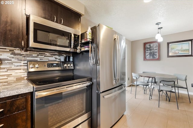 kitchen featuring dark brown cabinets, decorative backsplash, appliances with stainless steel finishes, and light countertops