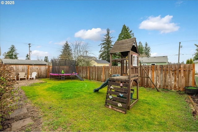 view of yard featuring a patio area, a trampoline, a fenced backyard, and a playground