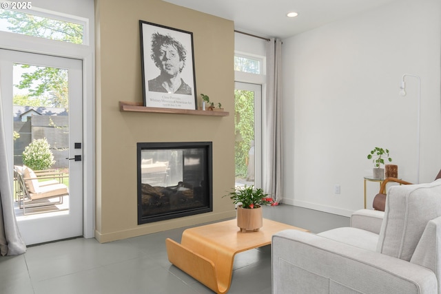 tiled living area with a multi sided fireplace, baseboards, and recessed lighting