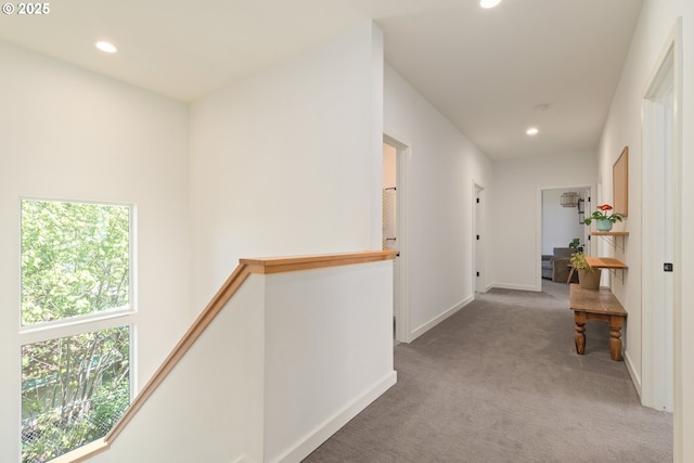 hallway featuring carpet floors, recessed lighting, a wealth of natural light, and an upstairs landing
