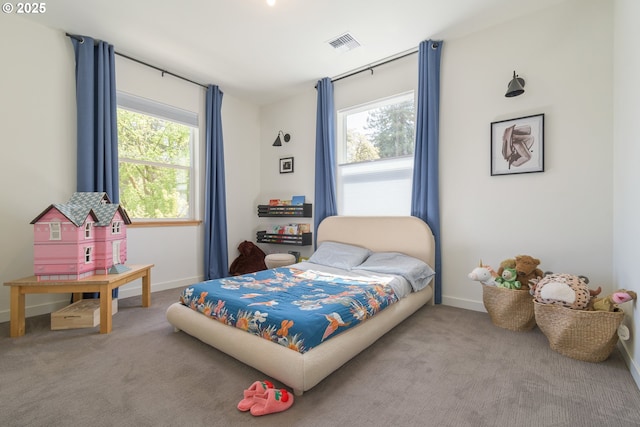 bedroom with visible vents, carpet flooring, and multiple windows