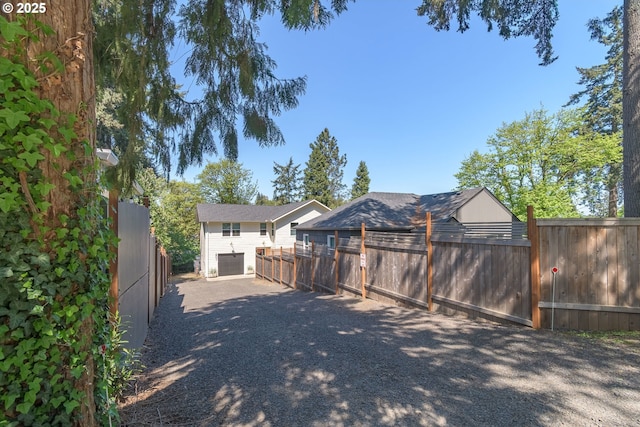 exterior space featuring fence private yard, a garage, and driveway