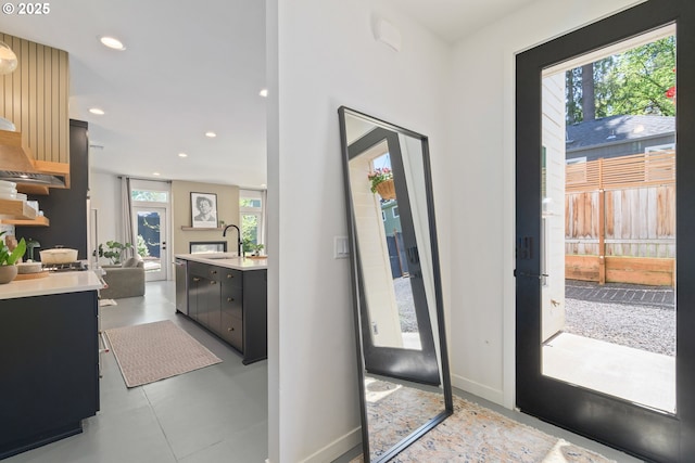 doorway featuring a sink, baseboards, and recessed lighting