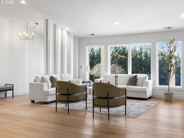 living room with light wood-type flooring and a chandelier