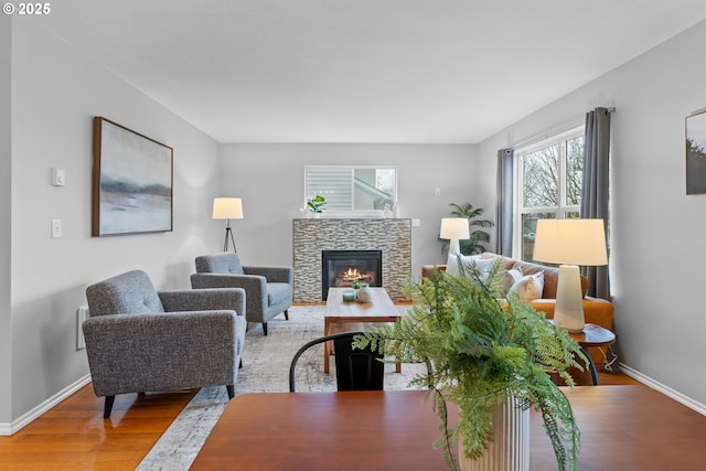 living room featuring a stone fireplace and hardwood / wood-style floors