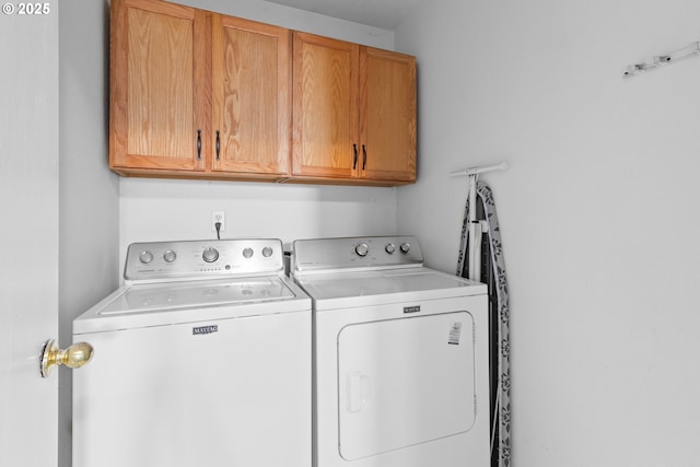 laundry area with cabinets and washing machine and clothes dryer