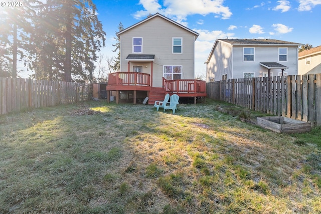 rear view of house featuring a deck and a lawn