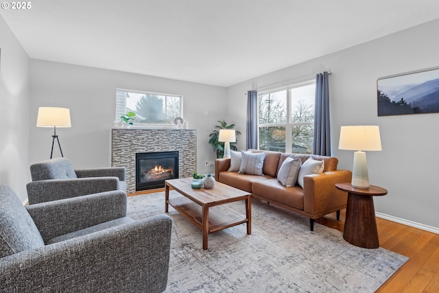 living room with a fireplace, wood-type flooring, and a healthy amount of sunlight