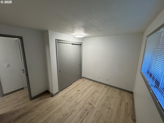 2420 Margery St, West Linn, OR 97068 - unfurnished bedroom with light wood finished floors, baseboards, a closet, and a textured ceiling