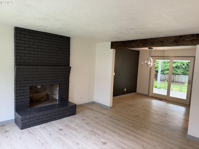 2420 Margery St, West Linn, OR 97068 - unfurnished living room with a textured ceiling, light wood-style flooring, a chandelier, baseboards, and a brick fireplace
