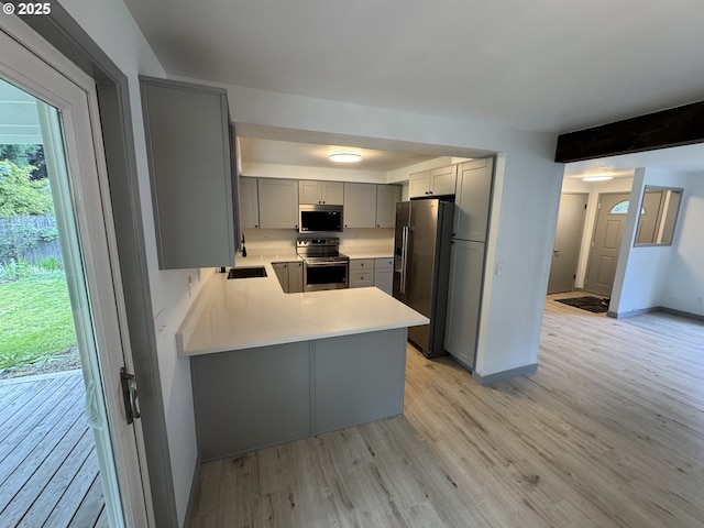 2420 Margery St, West Linn, OR 97068 - kitchen with appliances with stainless steel finishes, gray cabinets, light wood-style floors, and light countertops