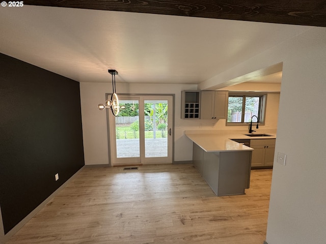 2420 Margery St, West Linn, OR 97068 - kitchen with a sink, light wood-type flooring, light countertops, a peninsula, and decorative light fixtures