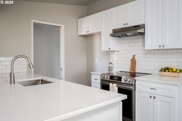 kitchen with stainless steel electric stove, a sink, white cabinets, and under cabinet range hood