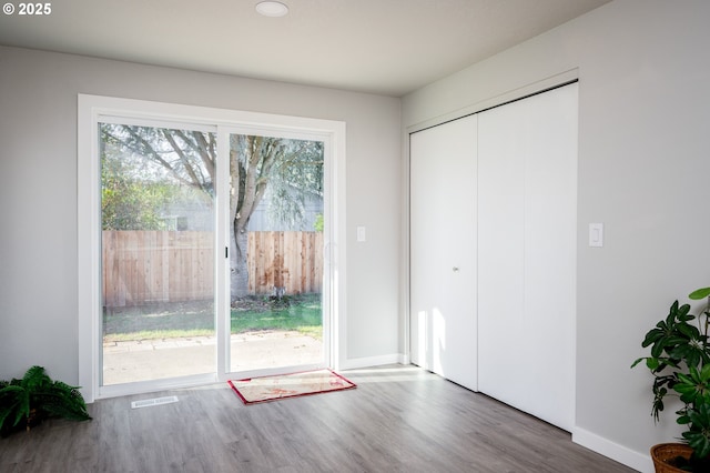 doorway to outside with visible vents, baseboards, and dark wood-style flooring