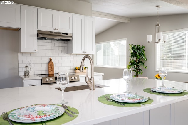 kitchen featuring vaulted ceiling with beams, white cabinetry, and under cabinet range hood