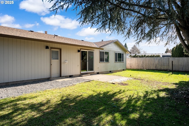 back of house featuring crawl space, fence, a patio, and a lawn