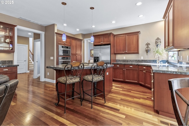 12919 NE 37th Ct, Vancouver, WA 98686 - kitchen featuring stainless steel fridge with ice dispenser, light wood-style floors, a kitchen breakfast bar, a kitchen island, and pendant lighting