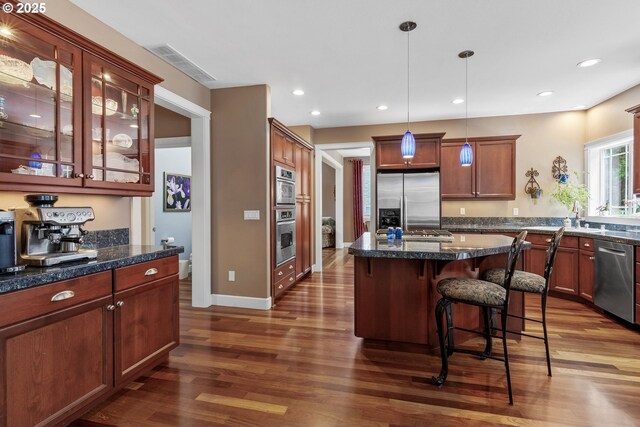 12919 NE 37th Ct, Vancouver, WA 98686 - kitchen featuring stainless steel appliances, dark wood-style flooring, a kitchen bar, decorative light fixtures, and recessed lighting