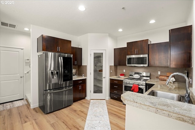 4891 NW Blandy Ter, Portland, OR 97229 - kitchen with appliances with stainless steel finishes, a sink, light wood-style floors, dark brown cabinetry, and recessed lighting