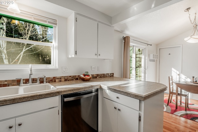 kitchen with white cabinetry, dishwasher, sink, and kitchen peninsula