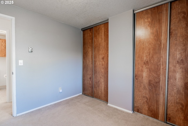 unfurnished bedroom featuring light colored carpet and a textured ceiling