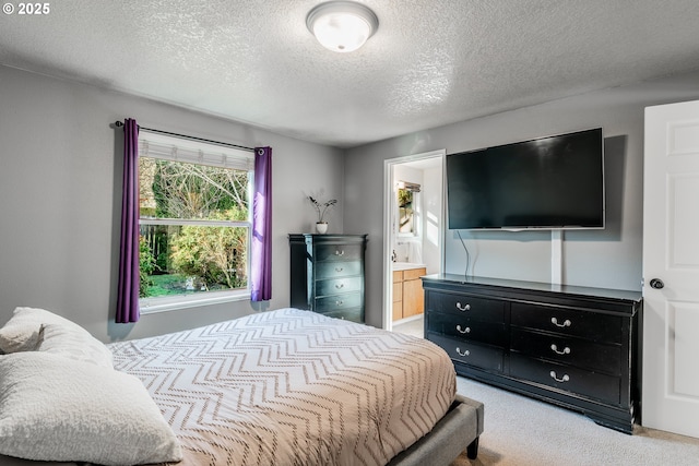 bedroom featuring connected bathroom, light colored carpet, and a textured ceiling