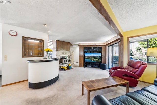 living room with light carpet, a textured ceiling, a fireplace, and baseboards