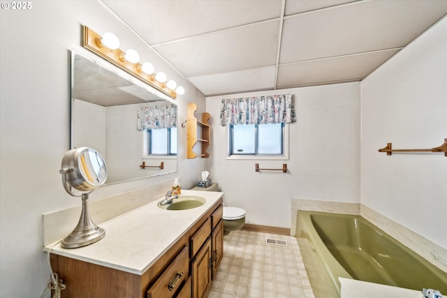 bathroom featuring a garden tub, toilet, vanity, visible vents, and tile patterned floors