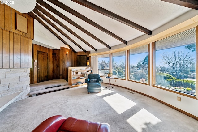 unfurnished room featuring baseboards, beam ceiling, visible vents, and carpet flooring