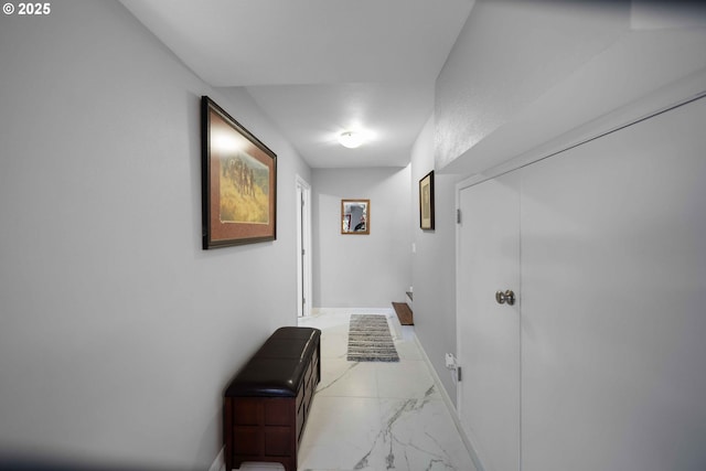 hallway featuring marble finish floor and baseboards