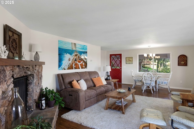living room with baseboards, a chandelier, and wood finished floors