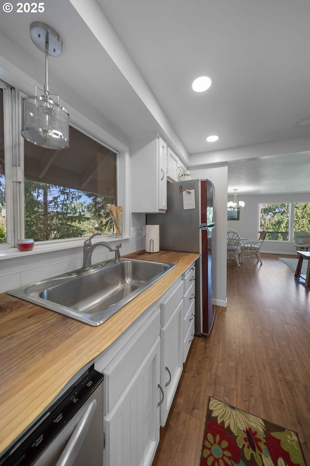 kitchen featuring white cabinets, a sink, recessed lighting, a chandelier, and appliances with stainless steel finishes