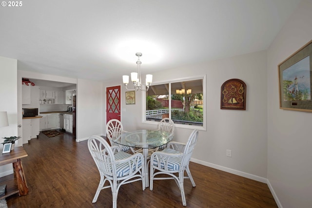 dining space with dark wood finished floors, baseboards, and an inviting chandelier
