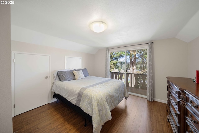 bedroom featuring lofted ceiling, access to outside, baseboards, and wood finished floors