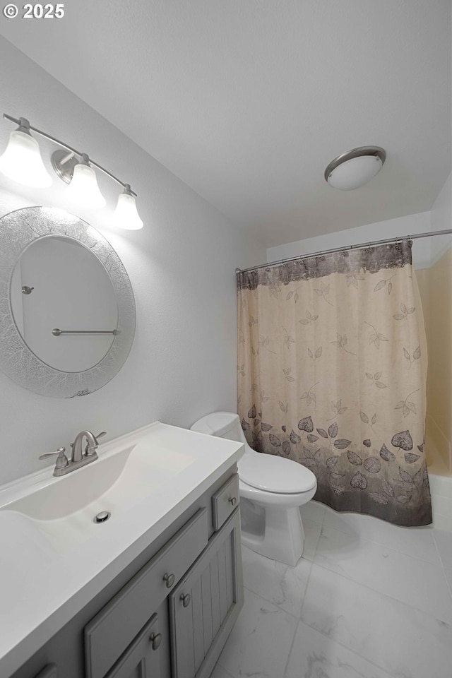 full bathroom with shower / tub combo with curtain, vanity, marble finish floor, and toilet