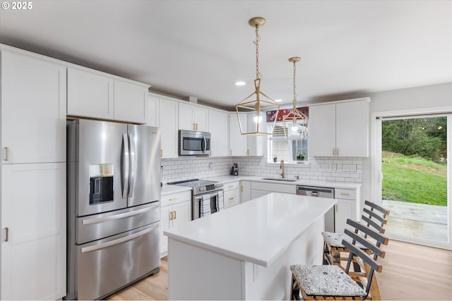 110 Axis Rd, Castle Rock, WA 98611 - kitchen with appliances with stainless steel finishes, a sink, light countertops, a breakfast bar, and healthy amount of natural light