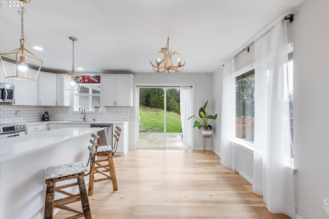 110 Axis Rd, Castle Rock, WA 98611 - kitchen featuring appliances with stainless steel finishes, tasteful backsplash, light countertops, a sink, and a kitchen bar