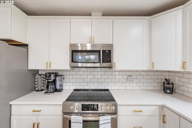 110 Axis Rd, Castle Rock, WA 98611 - kitchen with stainless steel appliances, white cabinetry, light countertops, and backsplash