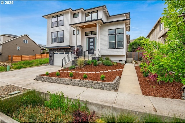 contemporary home featuring fence, concrete driveway, and a garage