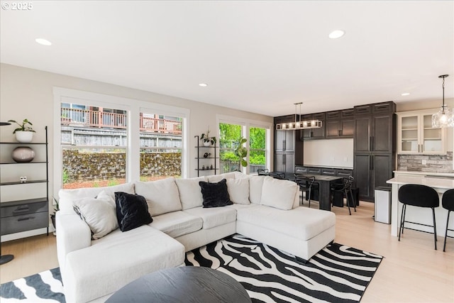 living area with light wood-style flooring and recessed lighting