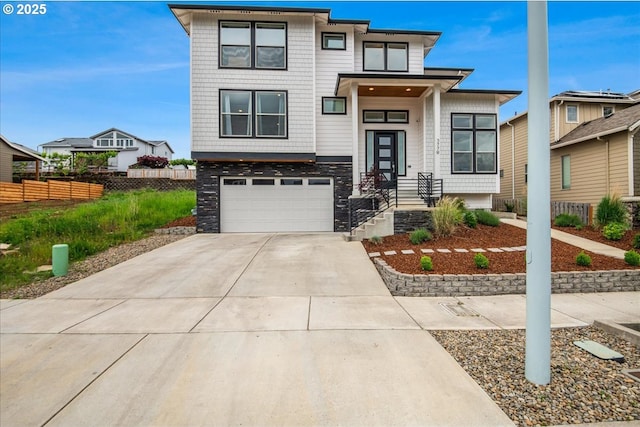 view of front facade featuring fence, an attached garage, and driveway