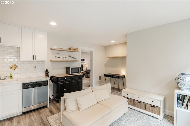 living area with light wood finished floors, recessed lighting, and baseboards